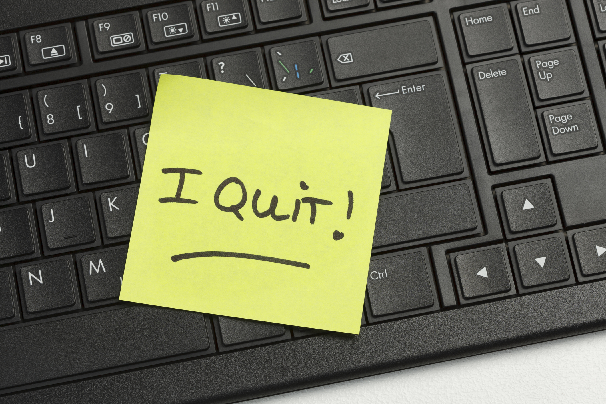 Image of a post-it note that reads "I quite" affixed to a computer keyboard